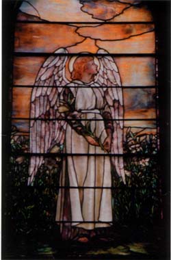 [Photo of a
stained glass window featuring a large winged angel standing and gazing
thoughtfully toward heaven]